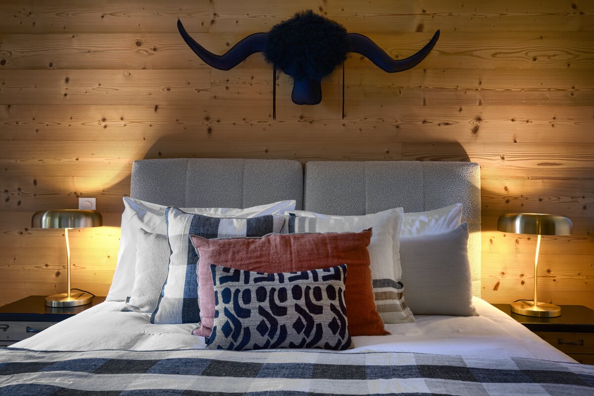 A bed with pillows on it and a horn hanging above it