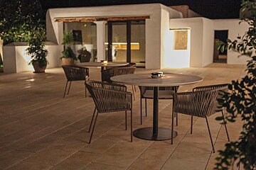 A patio area with tables and chairs at night