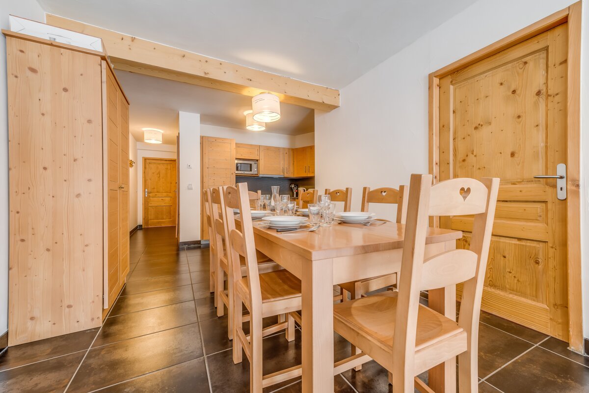 A dining room with a wooden table and chairs