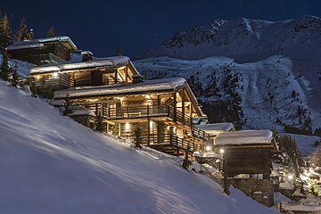 A snowy mountain with a house in the foreground