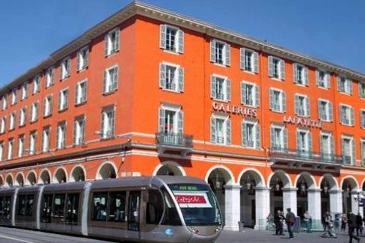 A large orange building with a train parked in front of it