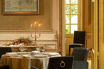 Restaurant in the hotel d'europe with green hard back chairs and candle holders on tables