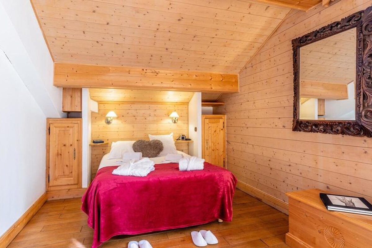 A bedroom with a bed and a mirror on the wall