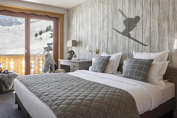 A bedroom with a skier on the wall above the bed