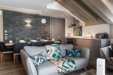 A living room with a couch and a clock on the wall