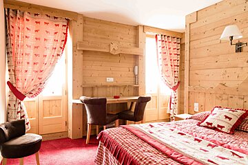 A bedroom with a bed a desk and chairs