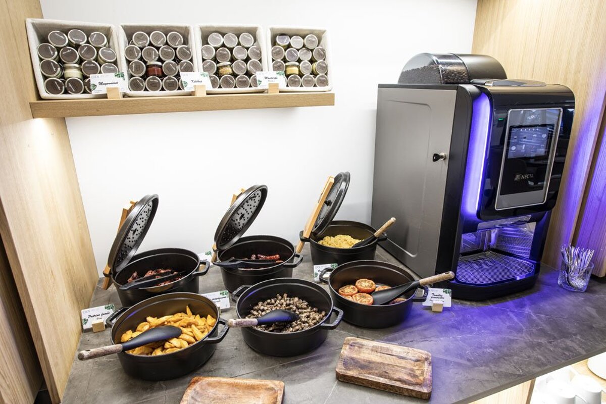 A buffet table with pots of food and a coffee machine