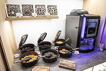 A buffet table with pots of food and a coffee machine