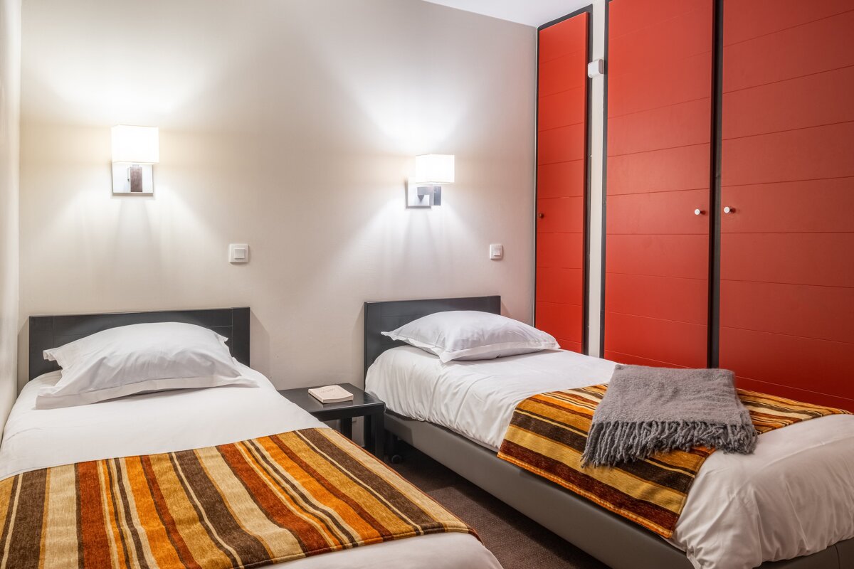 A bedroom with two beds and a red closet