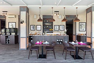 A restaurant with tables and chairs and a buffet