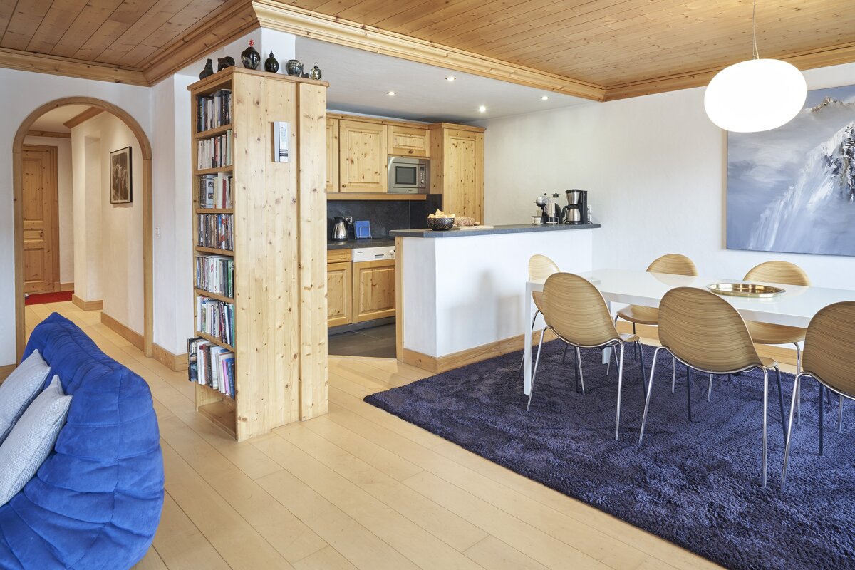 A dining room with a table and chairs and a blue couch