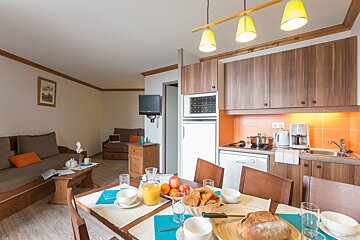 A kitchen and dining area with a bread loaf on the table