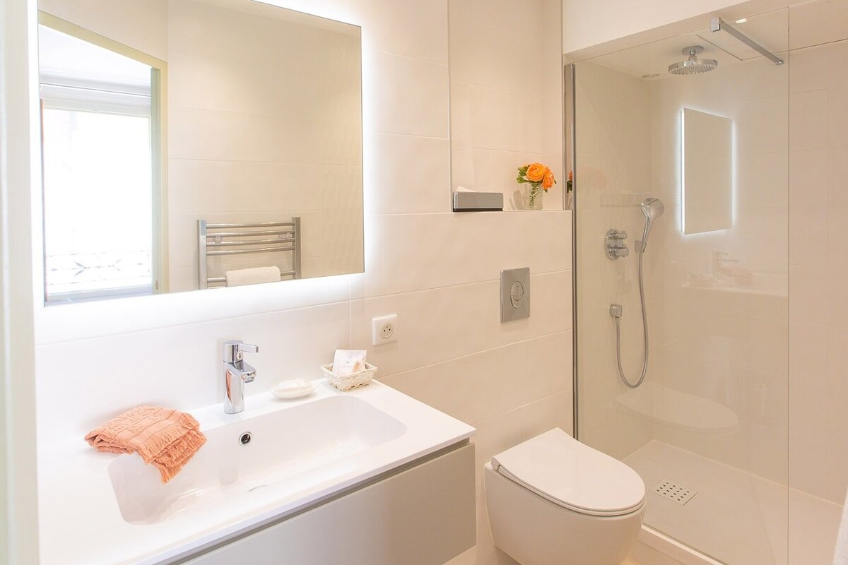 A bathroom with a toilet a sink and a shower