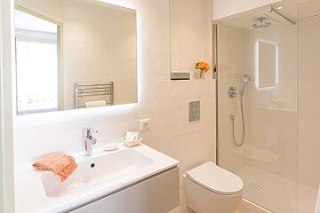 A bathroom with a toilet a sink and a shower