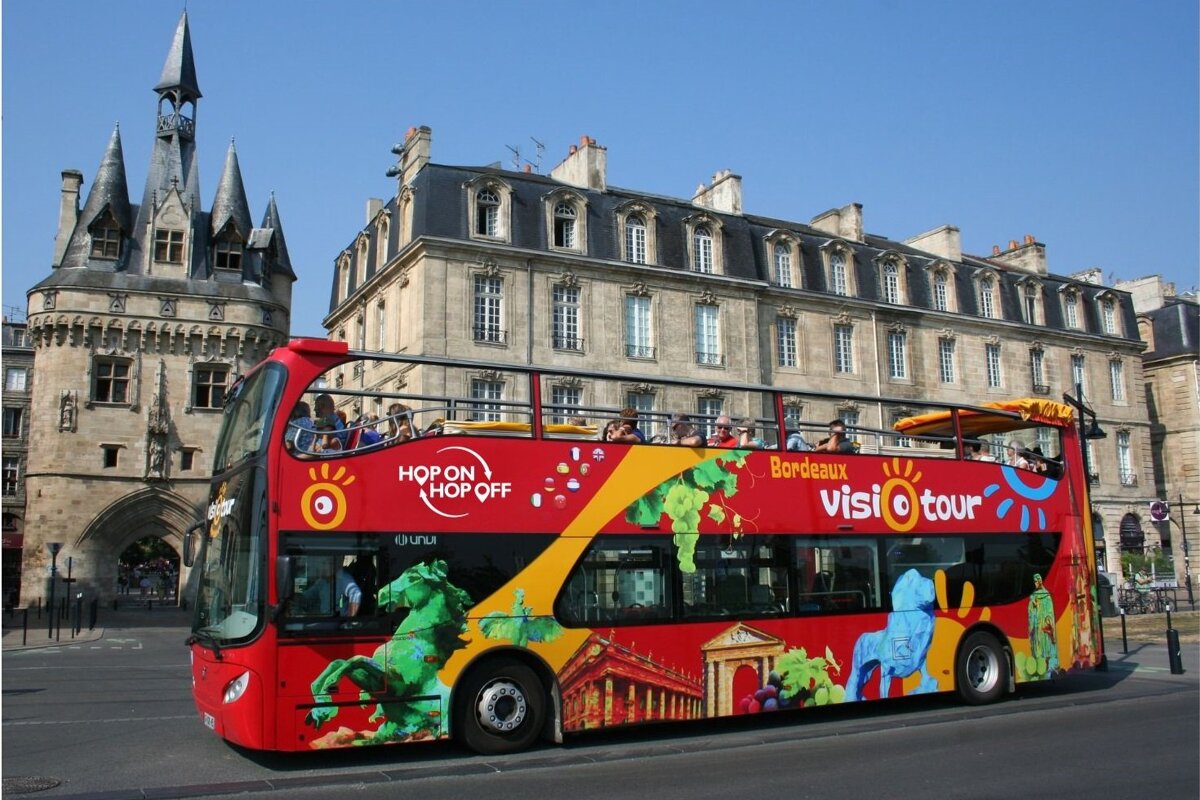 A double decker bus that says hop on hop off on the side