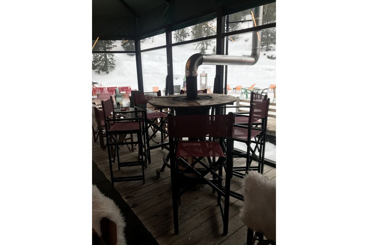 A restaurant with tables and chairs and a heater on the table
