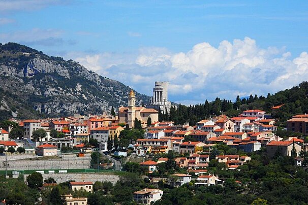 a pretty town with red roof tops and a medieval tower