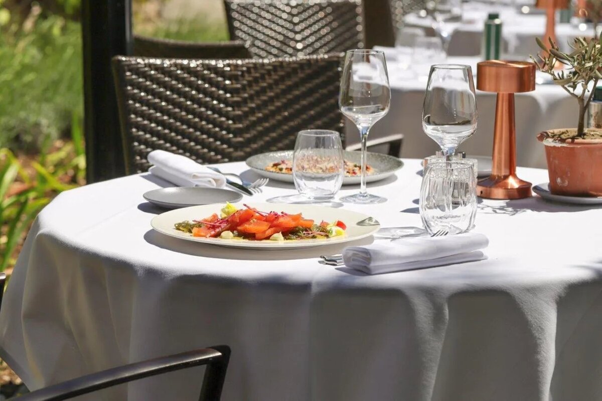A table with a plate of food and wine glasses on it