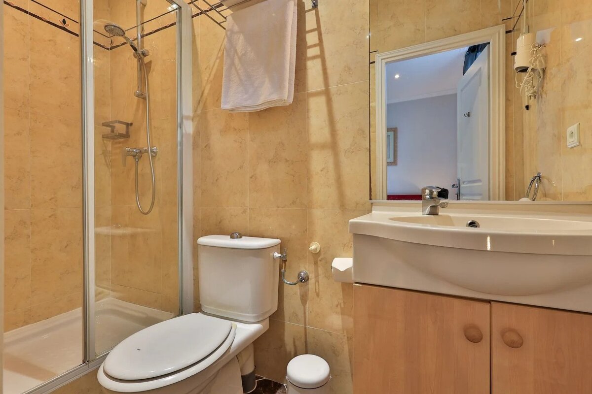 A bathroom with a toilet a sink and a shower