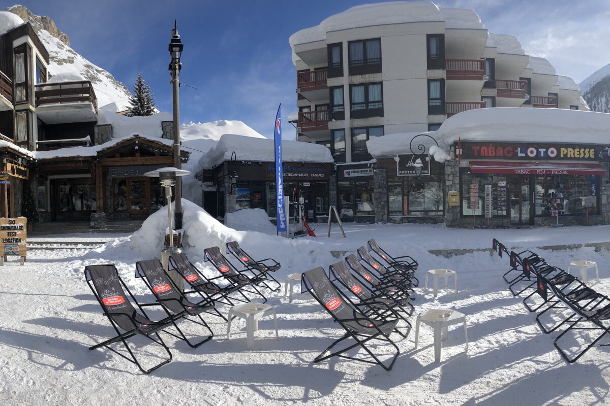 A row of chairs in front of a building that says tabac loto presse