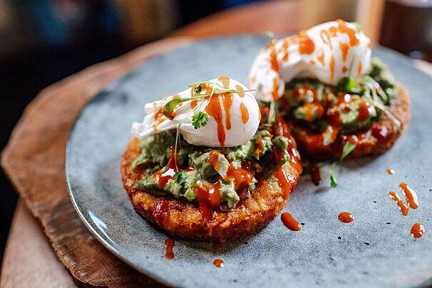A plate of food with guacamole and poached eggs