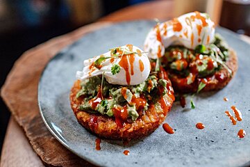 A plate of food with guacamole and poached eggs