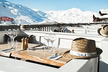 A straw hat with the word marelle on it sits on a table