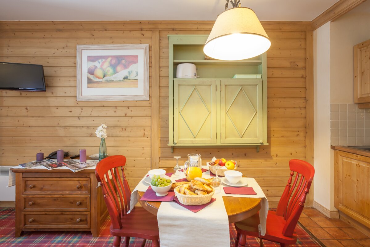 A dining room table with a basket of grapes on it