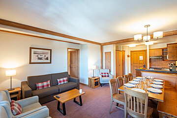 A living room with a couch and chairs and a dining table
