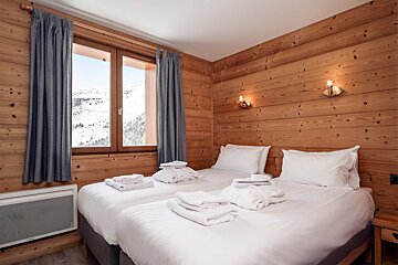 A bedroom with two beds and a window