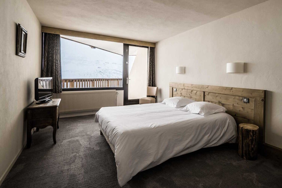 A hotel room with a bed and a television