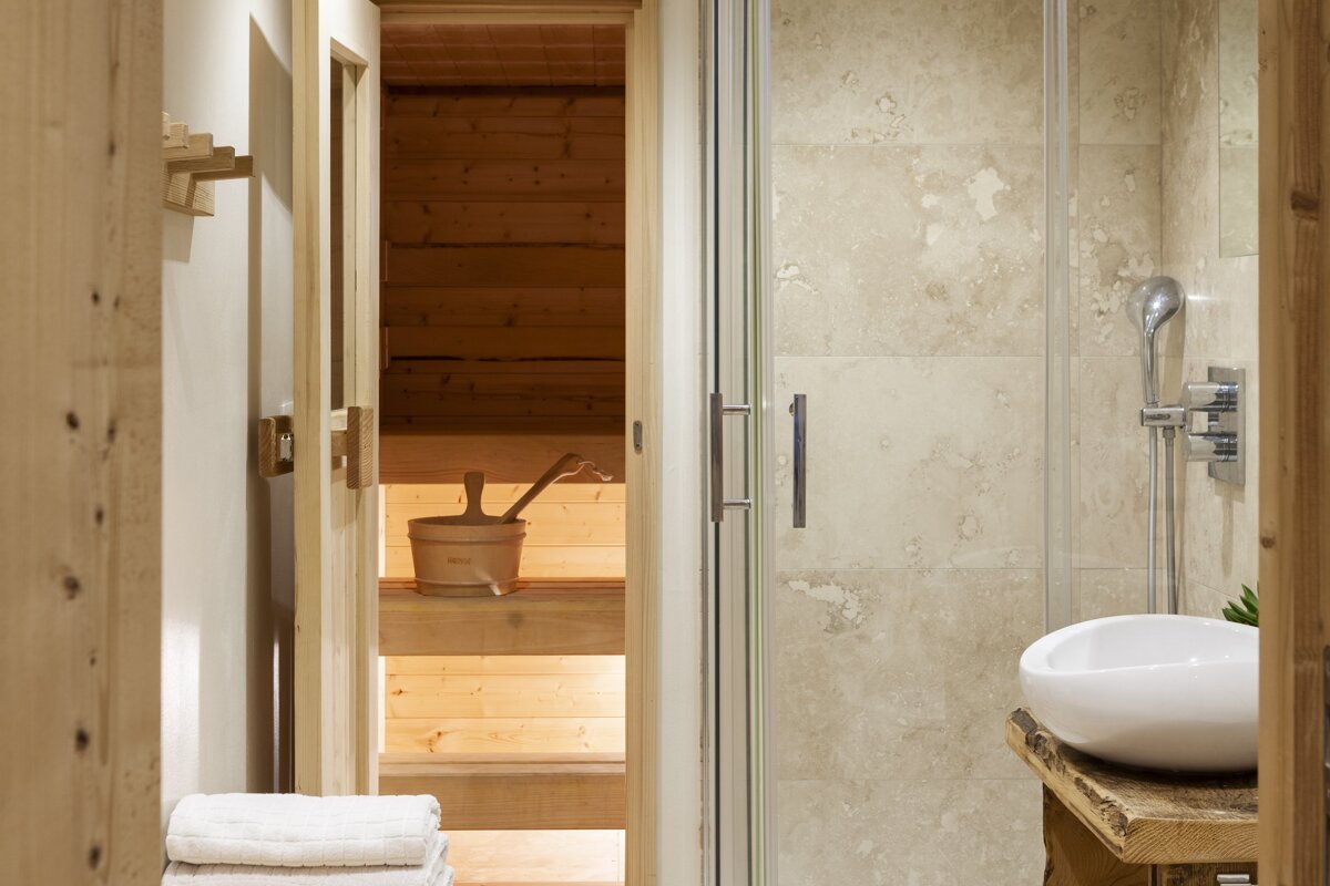 A bathroom with a wooden sauna and a white sink