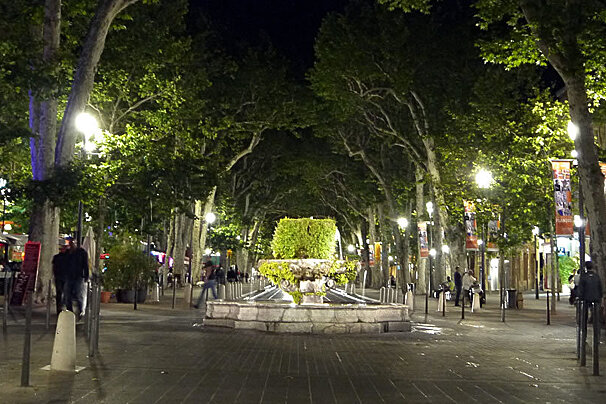 a fountain at night on a street in provence