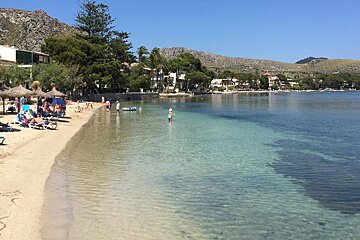 someone swimming off a narrow sandy beach