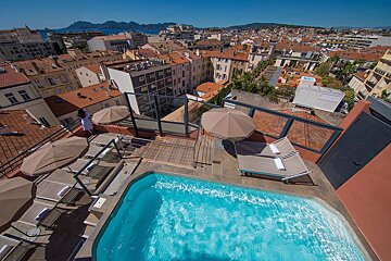 An aerial view of a swimming pool surrounded by chairs and umbrellas