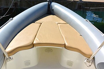 The front of a boat with a tan seat