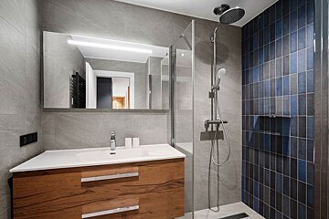 A bathroom with a sink and a walk in shower