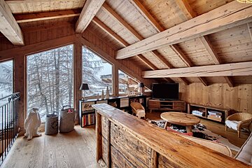 A living room with a flat screen tv and a wooden table