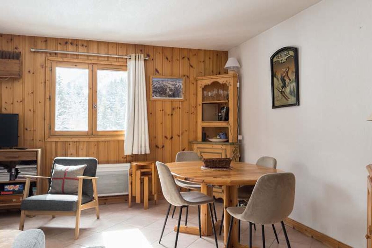 A living room with a table and chairs and a tv