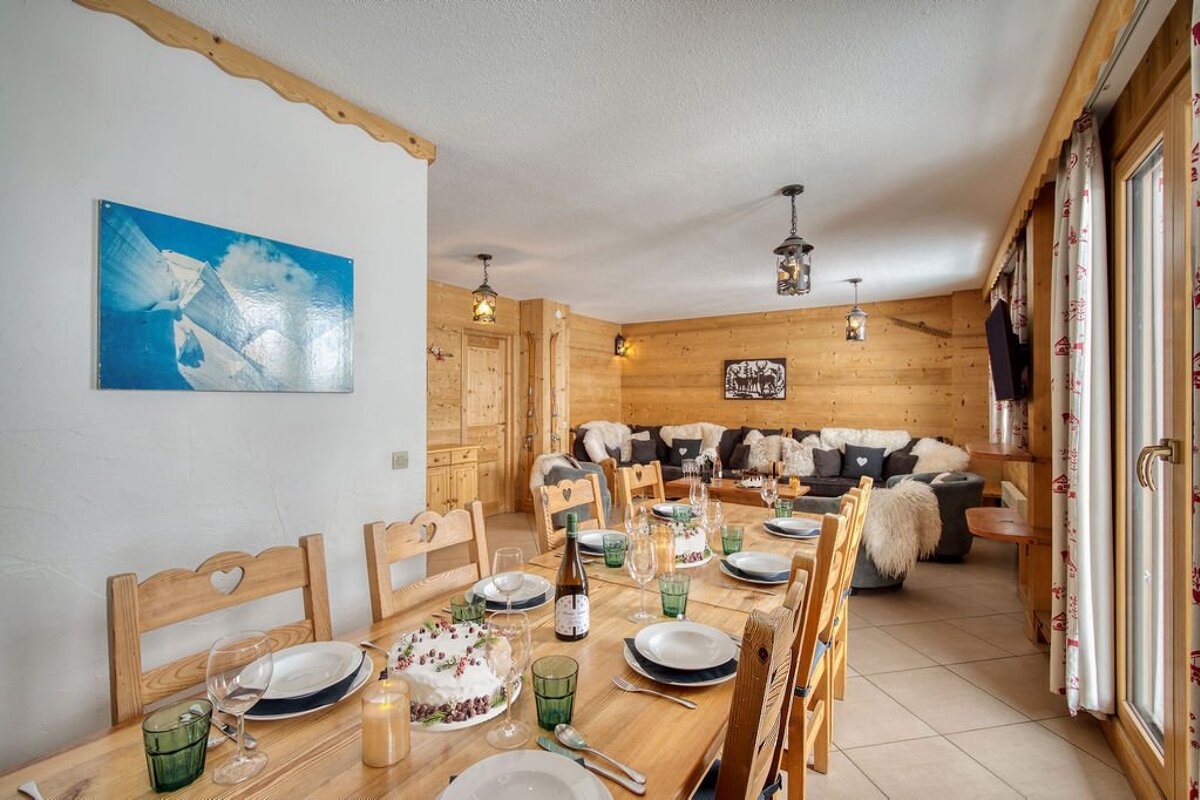 A dining table with a cake on it and a bottle of wine on it