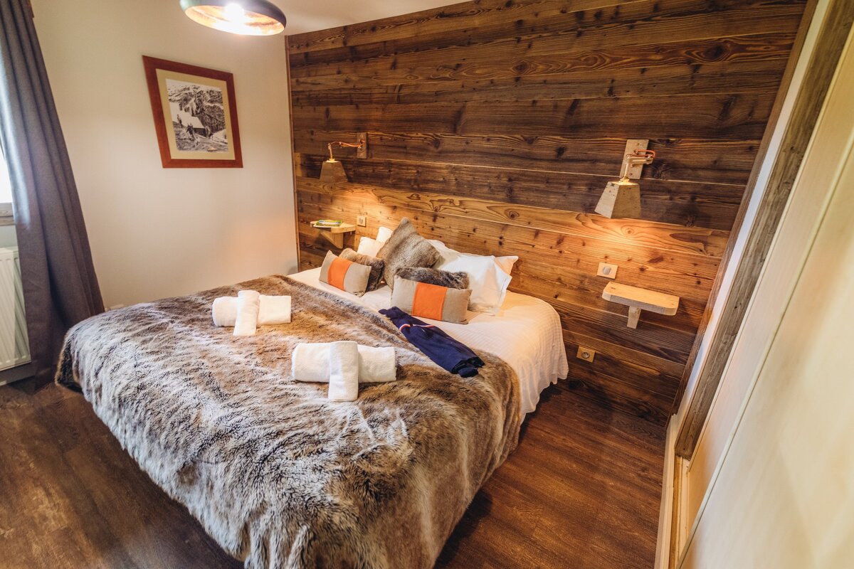 A bedroom with a bed and a wooden wall