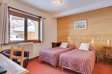 A hotel room with two beds and a chair