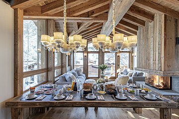 A large wooden table with plates of food on it