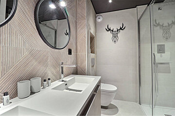 A bathroom with a deer head on the wall