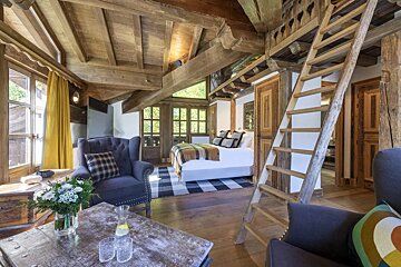 A bedroom with a ladder leading up to the second floor