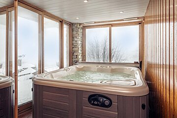A hot tub in a room next to a window