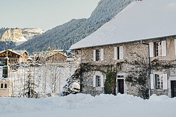 A snowy house with a mountain in the background