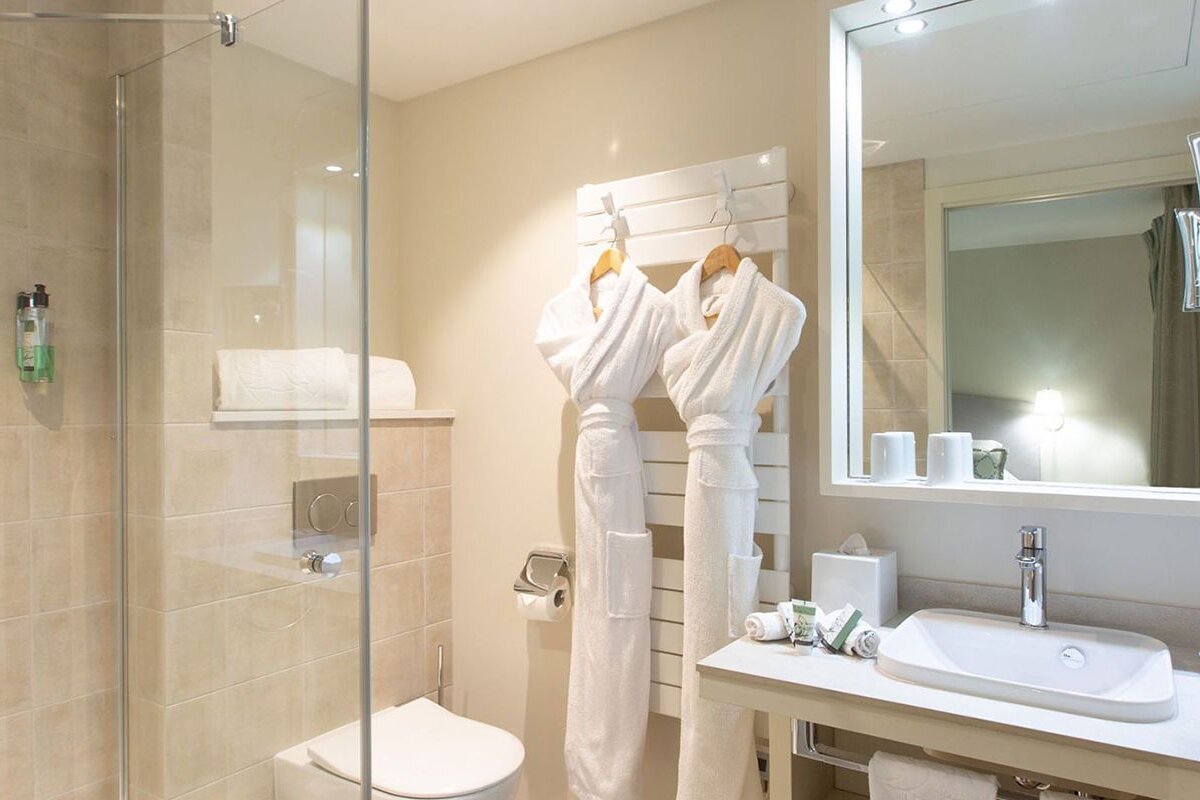 A bathroom with a toilet a sink and a mirror