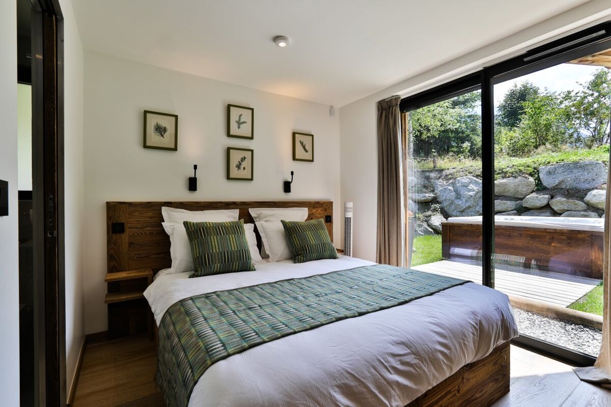 A bedroom with a large bed and a sliding glass door