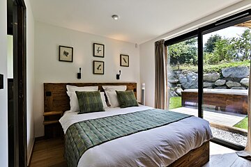 A bedroom with a large bed and a sliding glass door